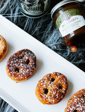 Donuts with ghost faced holes, with a Bellisari's Blistered Jalapeño and Fig Spread jar. 